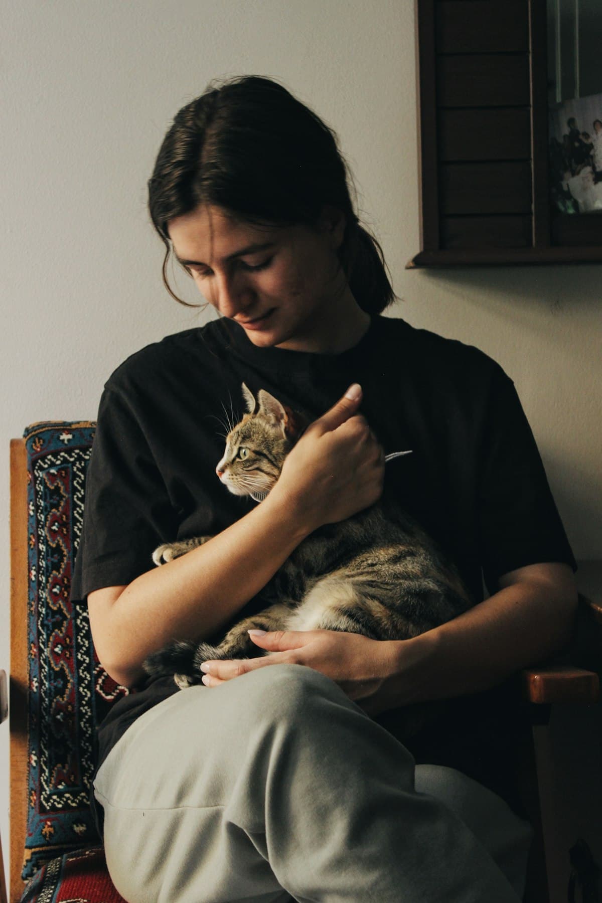 A person holding their cat at home